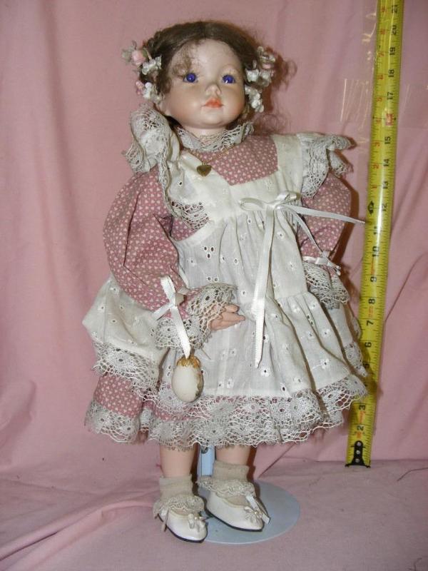lot 52 image: Porcelain Doll on stand, she has be...