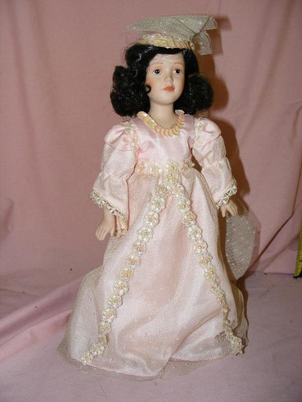 lot 55 image: Porcelain Doll with pink dress on s...