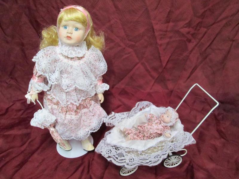 lot 32 image: Pair of porcelain dolls with carria...
