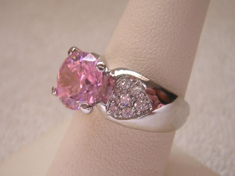 lot 125 image: Sparkling silver ring with pink cen...