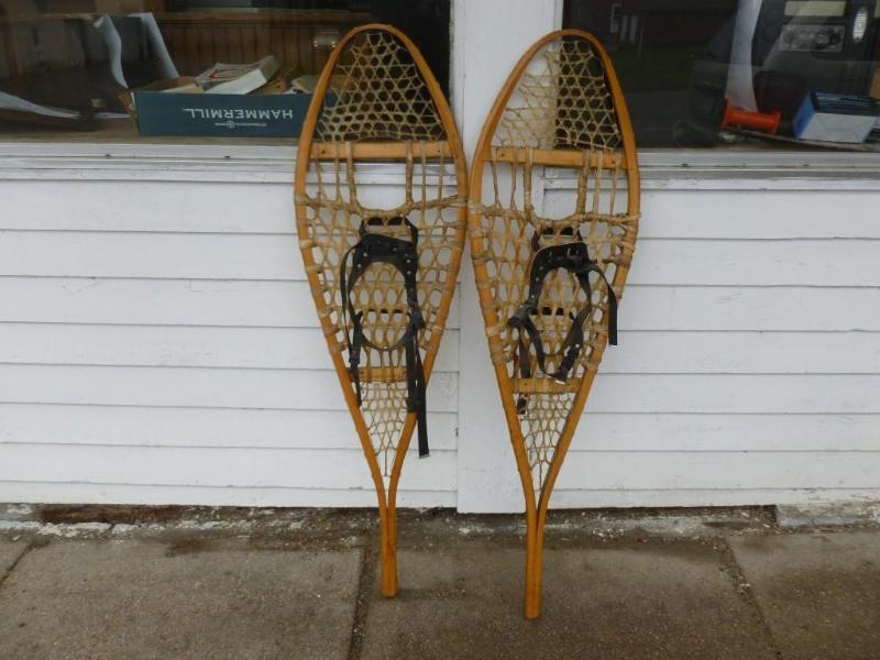 A pair of wooden framed snowshoes t...