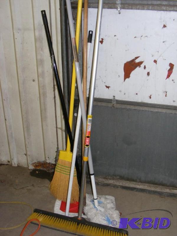 lot of brooms and dust mops...