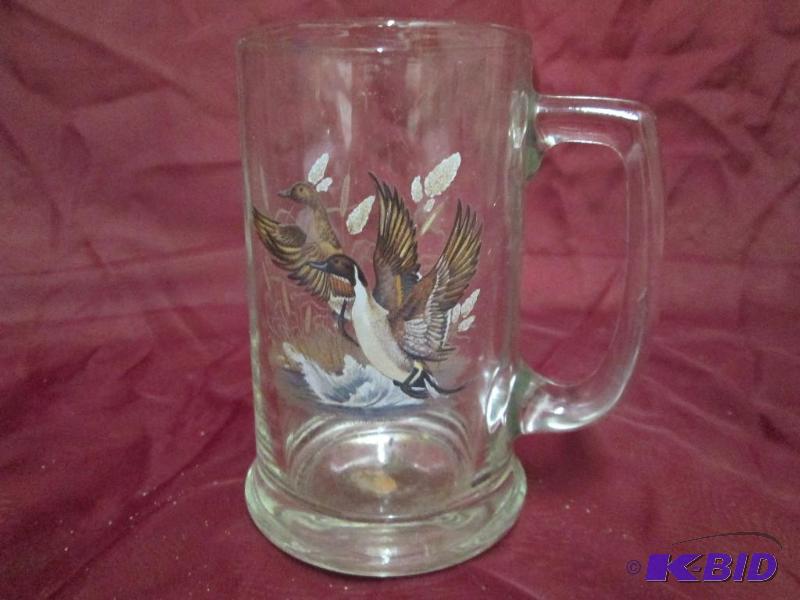Glass mug featuring ducks taking flight....
