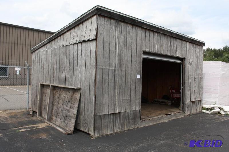 Wooden Shed with Shingled Roof and Garage Doo...