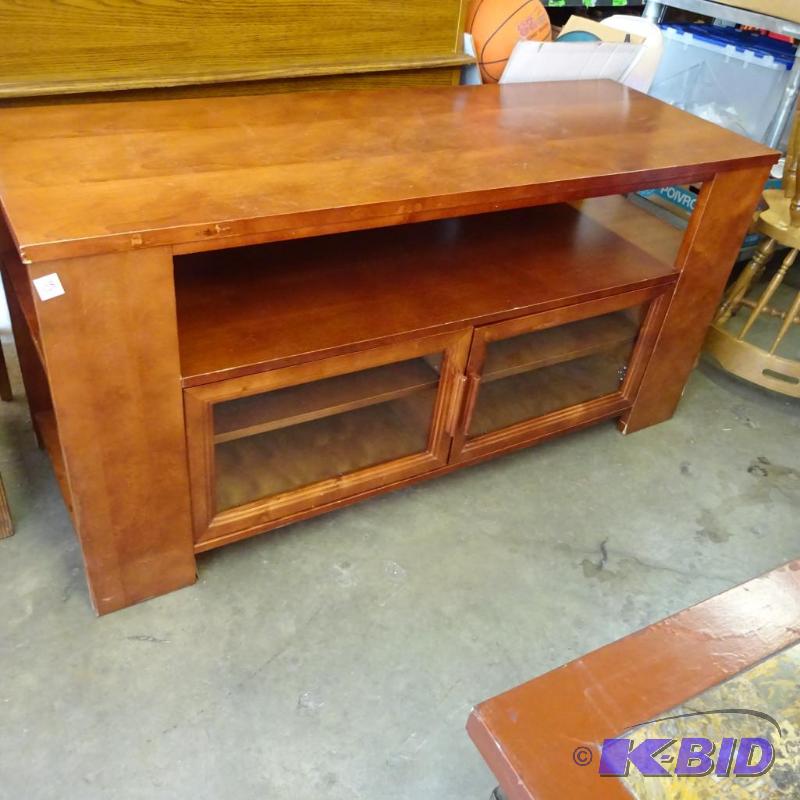 lot 128 image: Wood entertainment center. 2 glass doors fron...
