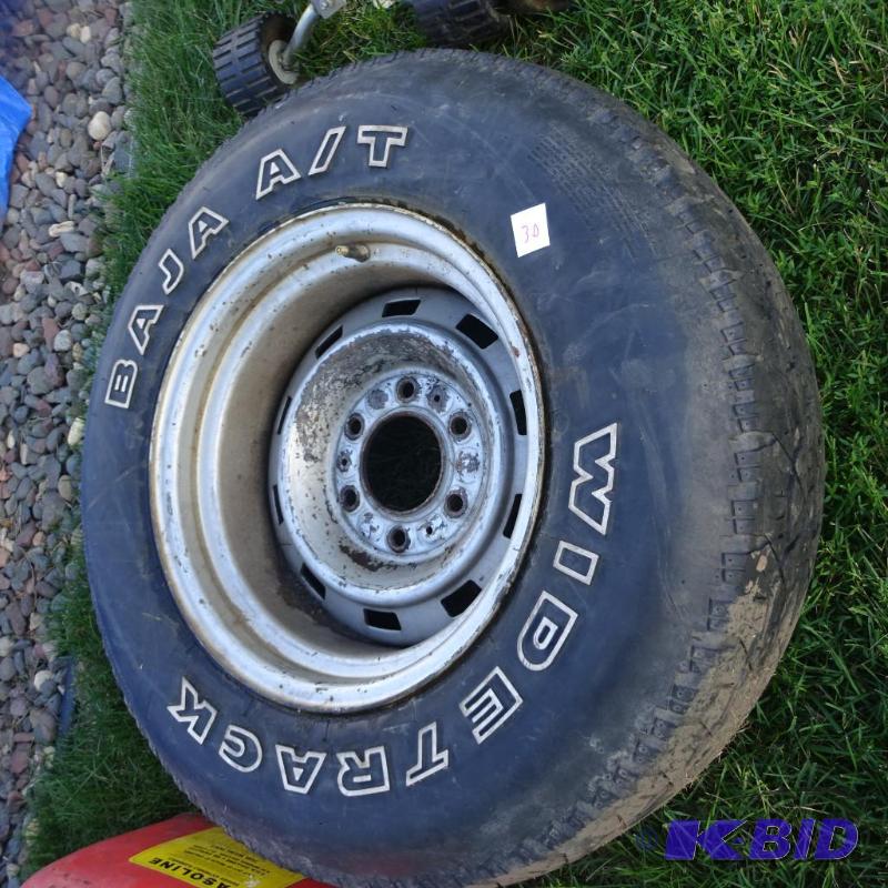 lot 30 image: P235175R15 Tire on 6 hole rim. Approx. 12 tr...