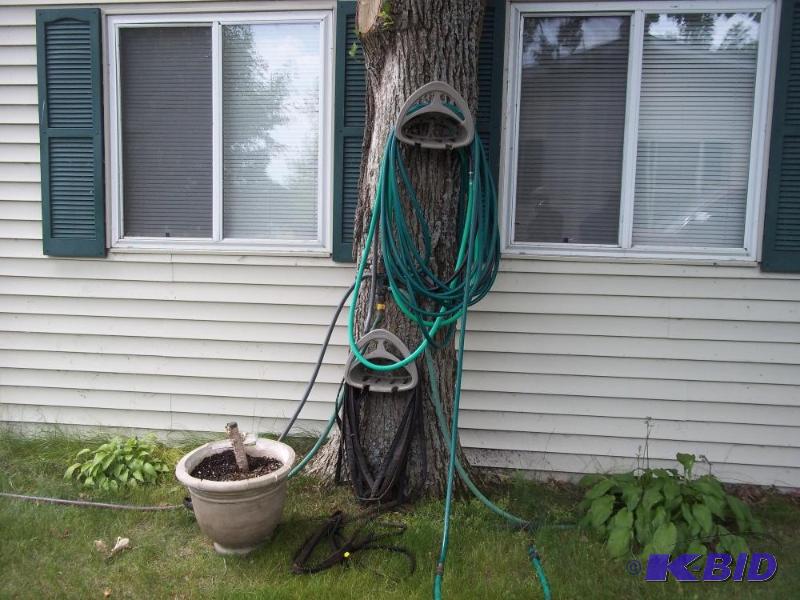 lot 34 image: Assortment of hoses, w 2 hangers, planter, soaker hose, (does not include tree connection)