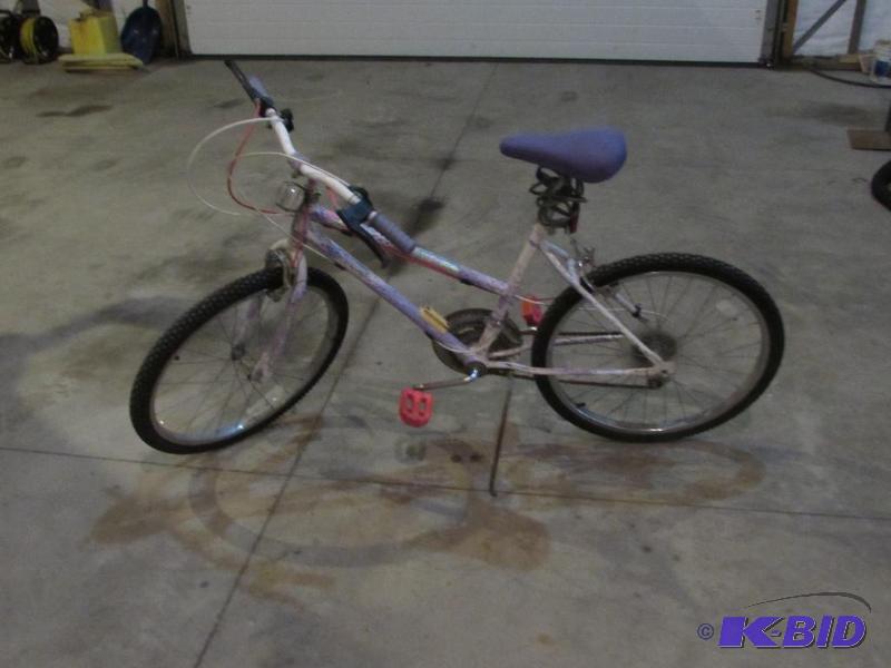 two girls bikes, one pink, one purple and whi...