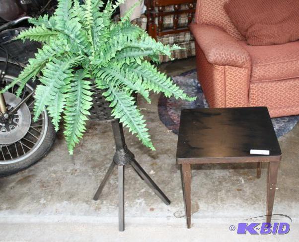 Square end table and green silk plant on stan...