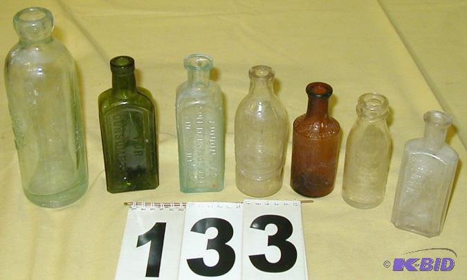 lot 133 image: Seven Vintage Embossed Glass Bottles Standard...