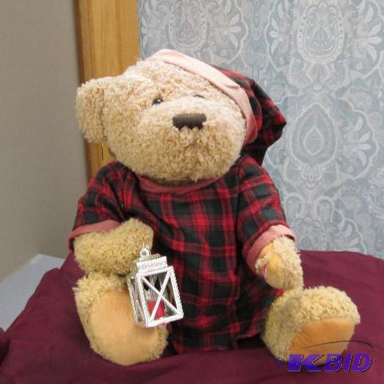 Stuffed teddy in his pj with a lantern plays...