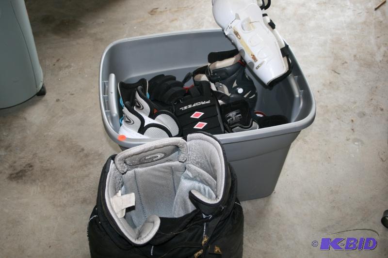 Bin of hockey equipment, breezers, skates, ro...