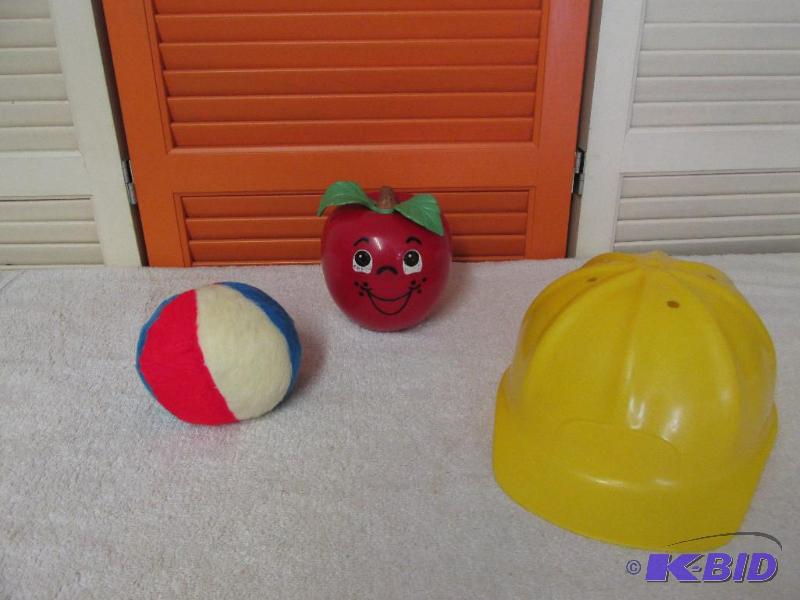 lot 86 image: Vintage Fisher Price Chiming Happy Apple, Red White and Blue Ball and a Small Hard Hat.