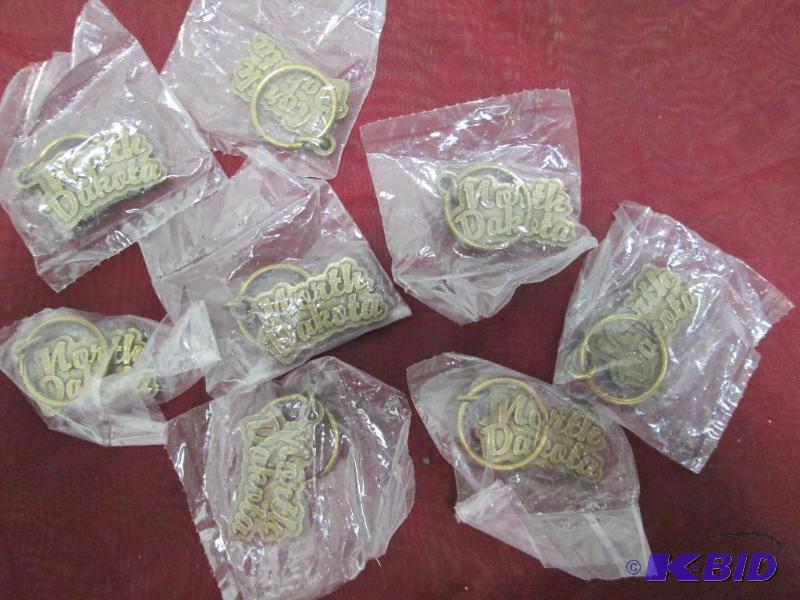 Qty 8 metal key chains that say North Dakota...
