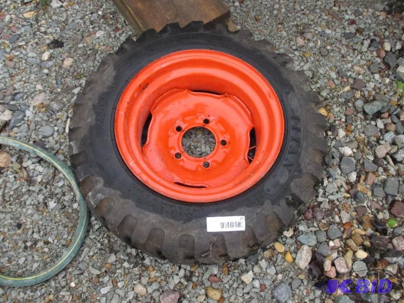 lot 25 image: 5.70 x 12NHS skidloader tire and rim, looks n...