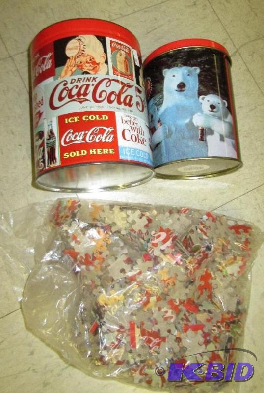 lot 107 image: Coca Cola tins with unopened puzzle...