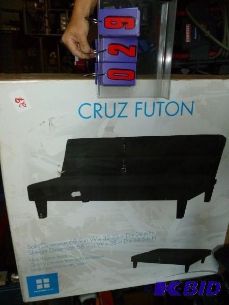 lot 29 image: Cruz futon. Black in color. Unassembled in bo...