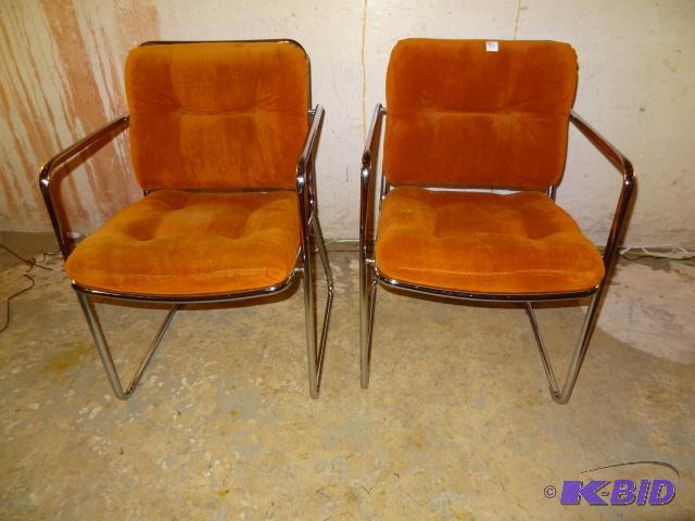Chrome chairs with orange velvet upholstery. ...