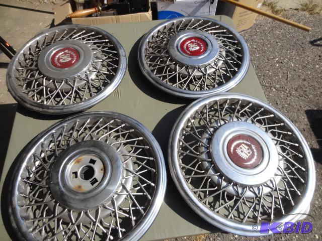 lot 159 image: 4 cadillac hub caps. 1 is missing center hub...