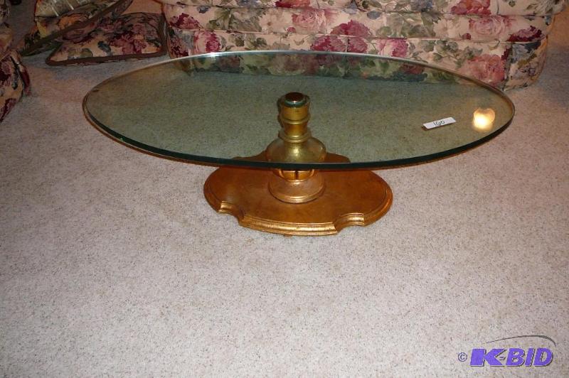 Glass oval coffee table with gold colored bas...