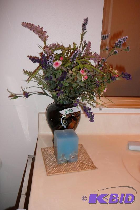 Decorative vase with fake flowers and candle ...