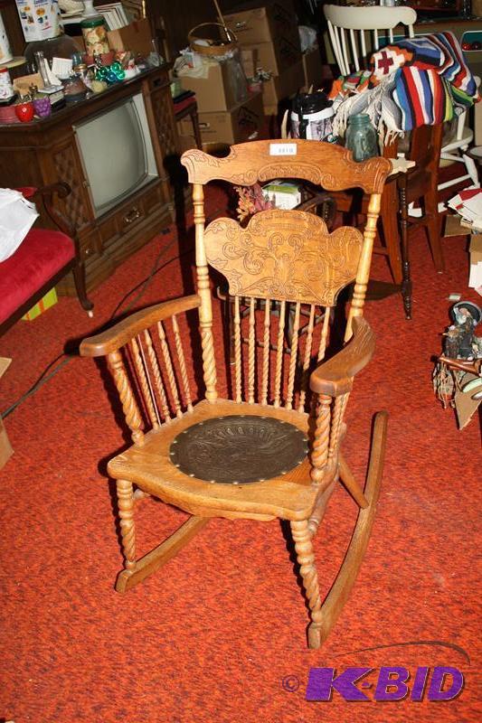 Wooden rocker with leather seat. Ornately car...
