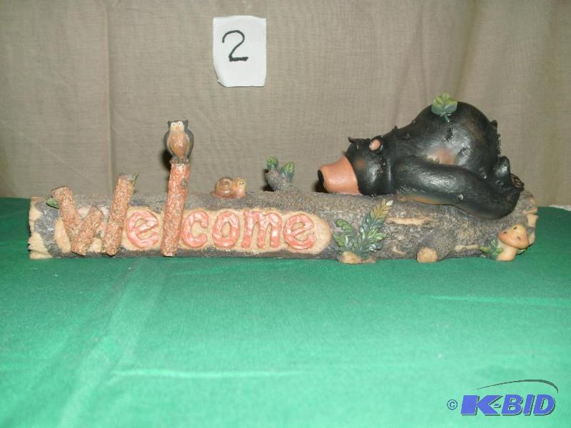 Bear laying on a log welcome sign. Little cri...