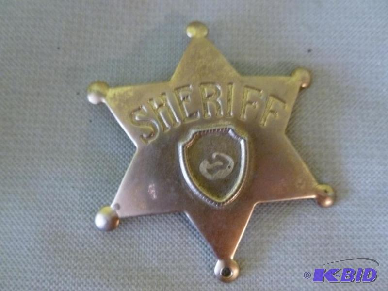 lot 43 image: Collectible metal sheriff badge that measures...