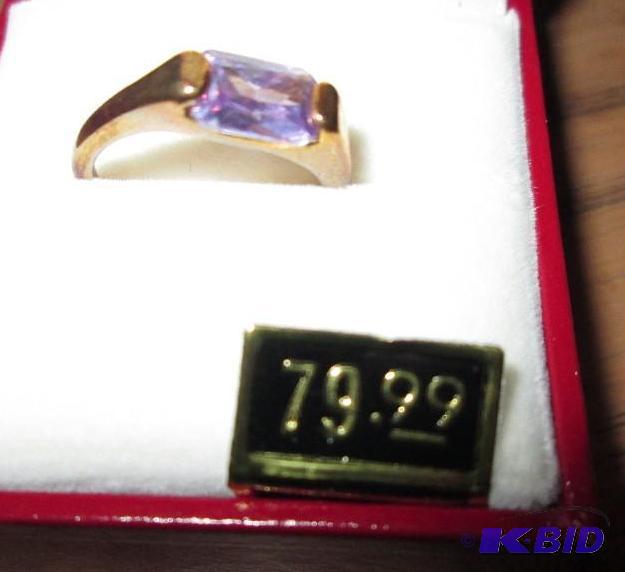 lot 33 image: Gold colored ring with purple stone...