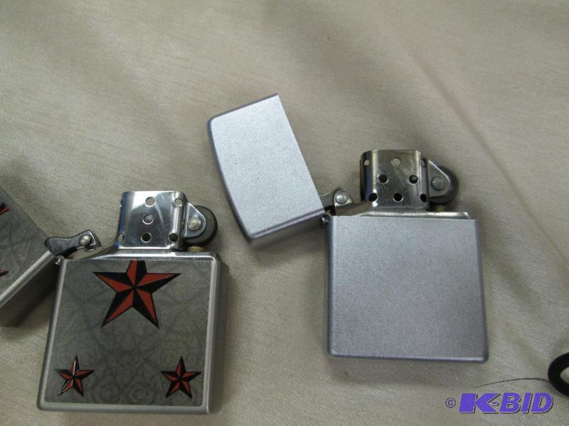 lot 215 image: Qty 2 silver one is a zippo and one with star...
