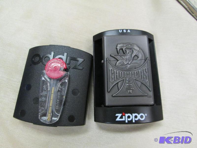 lot 219 image: Zippo lighter with a snake on it and says cho...