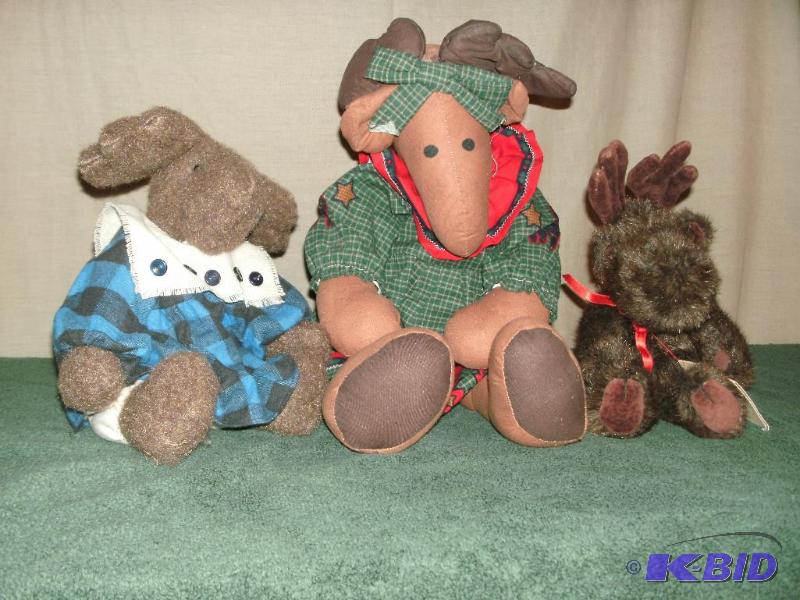3 stuffed moose. One with a blue dress, one w...