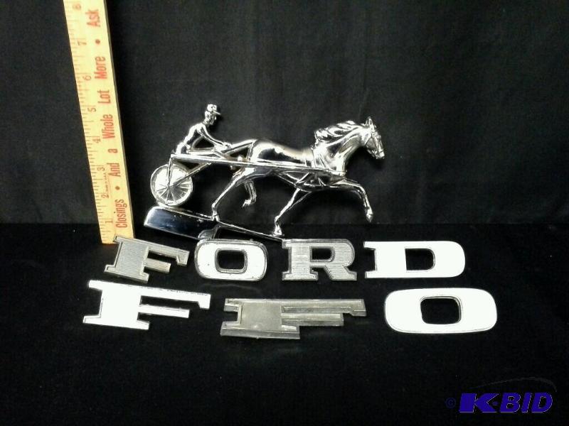 lot 97 image: Vintage Ford car or truck emblems and harness racing car emblem
