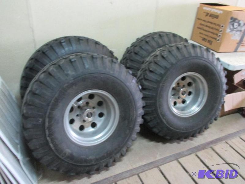 lot 36 image: 4 Chevy 6 bolt rims and tires, bogger tires a...
