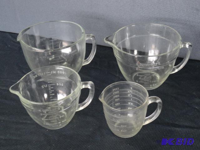 lot 42 image: Four clear measuring cups, two are marked Fir...
