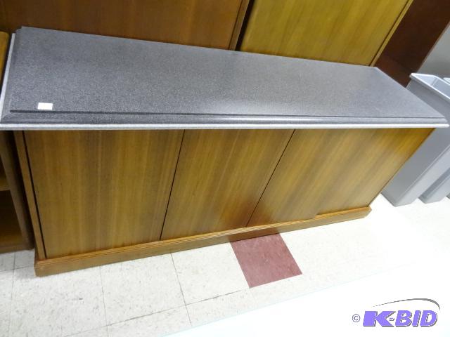lot 42 image: 4 door wood credenza. Has a granite looking t...