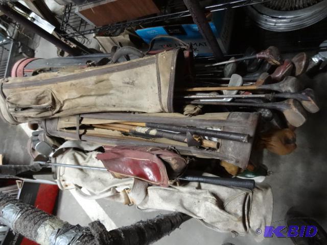 Cart full of vintage golf clubs. Some are woo...