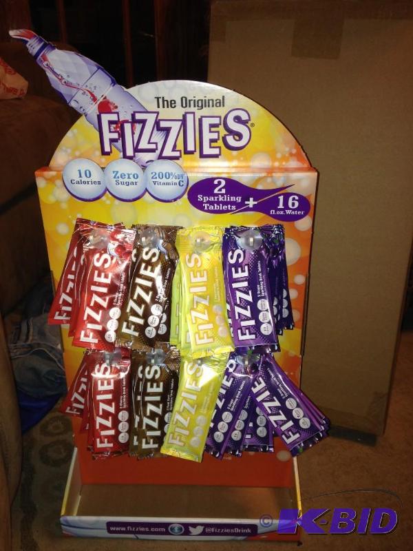 lot 24 image: Unopened Case of Fizzies.  Includes display board and 92 packages of Fizzies (2 per pack).  Just add these to water and you have a great beverage.  Grape, Cherry, Lemonade and Root Beer.