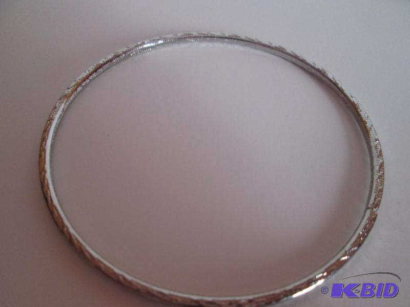 lot 102 image: sliver metal braclet with design outlining it...