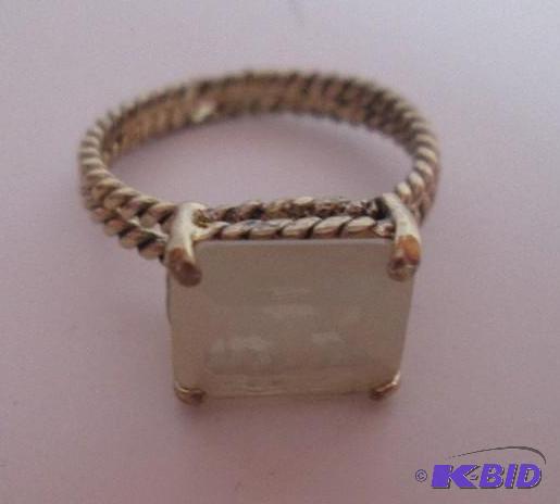 lot 43 image: Gold colored twist ring with white gem...