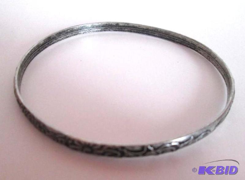 lot 61 image: sliver coloed metal braclet with designs outl...