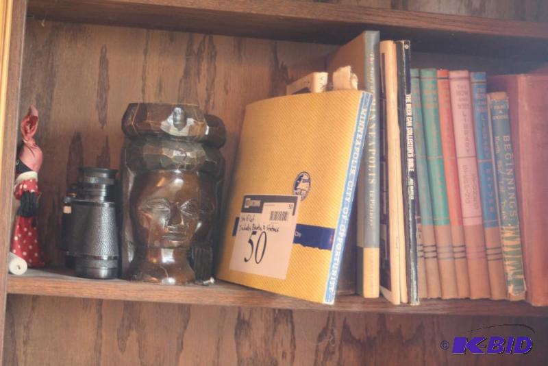 lot 50 image: Shelf Lot Includes Vintage Books, Wooden Statues, Binoculars, And More.