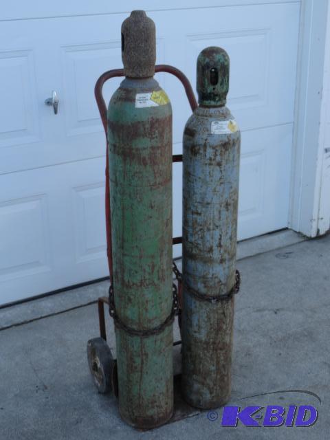 lot 27 image: Pair of oxygen tank with caps on two-wheel ca...