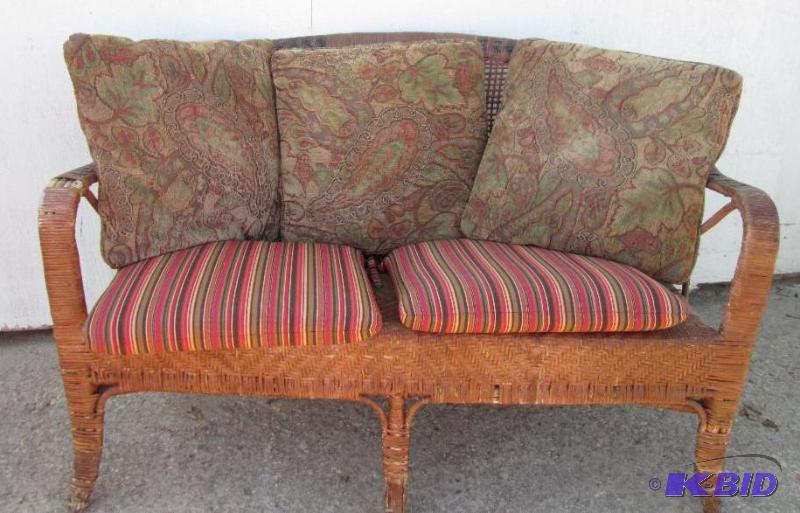 lot 106 image: Wicker 2 seat patio couch with cushions...