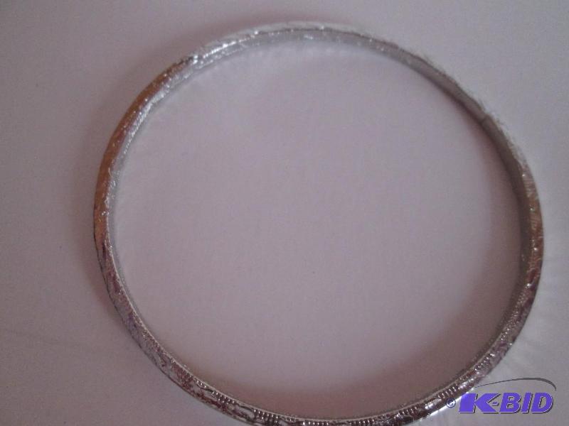 lot 136 image: sliver metal braclet with design outlining it...