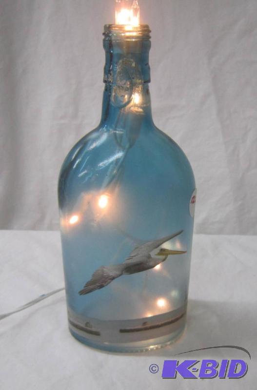 lot 562 image: NEW  9 High Lighted Electric Bottle Lamp with Pelican