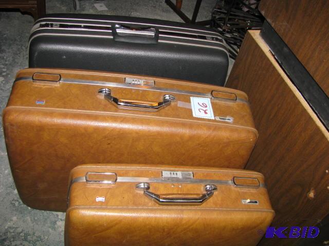 three hard sided suitcases two American touri...
