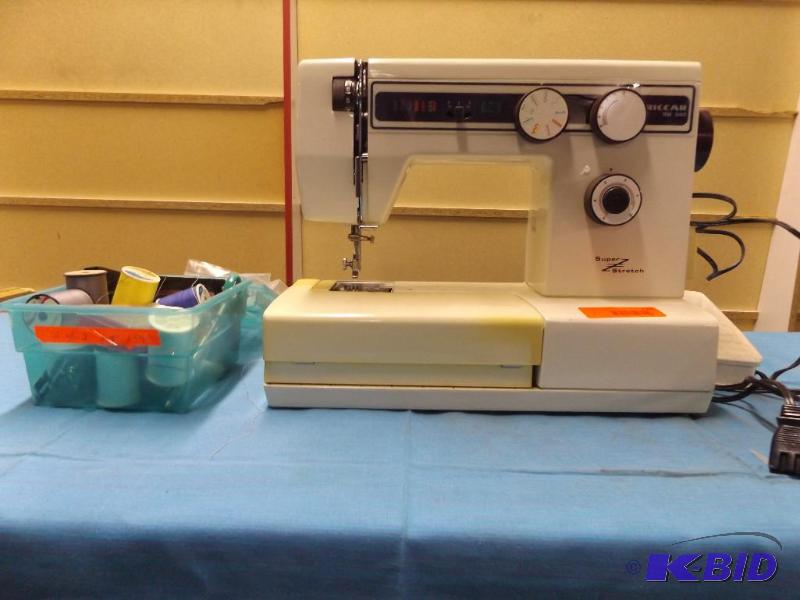 Sewing machine and small tote of threads and ...