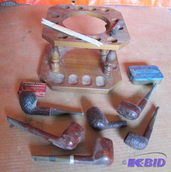 Vintage pipe rack with assorted pipes and tin...
