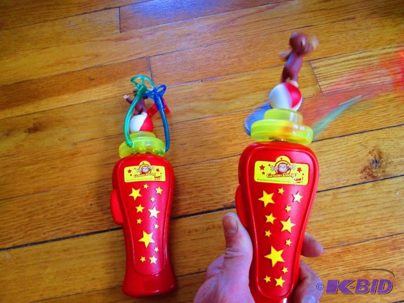 lot 209 image: 2 Curious George spinning toys, the 3 colored...